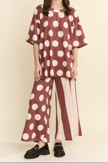Woman wearing a polka dot outfit with a plain background